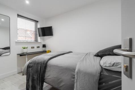 This inviting double bedroom features a cozy be...