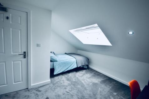 Bright and cozy single bedroom featuring a comf...