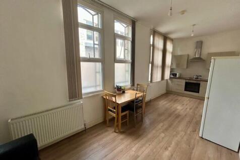 Bright and tidy kitchen space featuring large w...