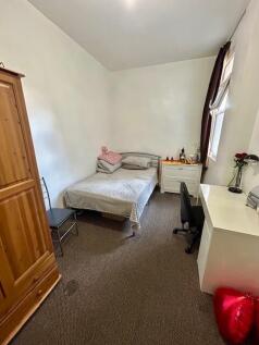 A cozy single bedroom featuring a comfortable b...
