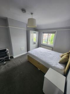 A bright double bedroom featuring a comfortable...