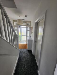 A bright and tidy hallway featuring a patterned...