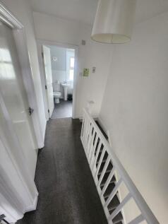 Bright and clean hallway with neutral decor and...