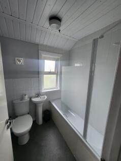 A bright and tidy bathroom suite featuring a wh...
