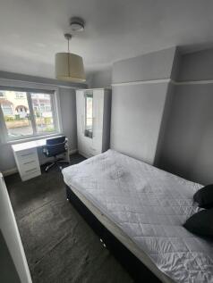 A bright double bedroom featuring a large windo...
