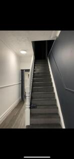 A clean and tidy hallway leading to a staircase...
