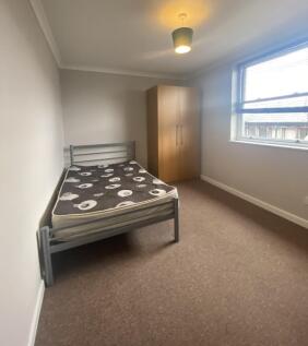 This well-lit double bedroom features ample spa...
