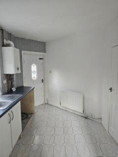 A compact kitchen space featuring white cabinet...