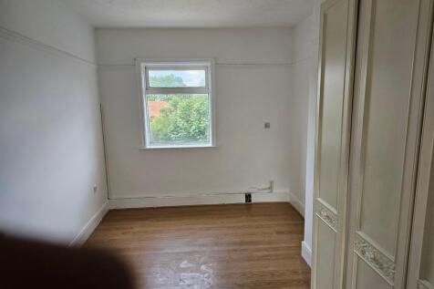 A tidy single bedroom featuring a large window ...