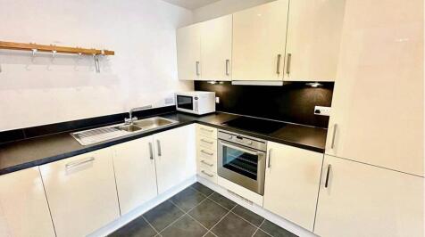 Modern and tidy kitchen featuring sleek white c...