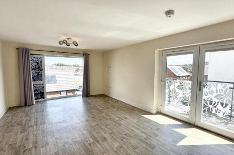 Bright and spacious living room featuring large...