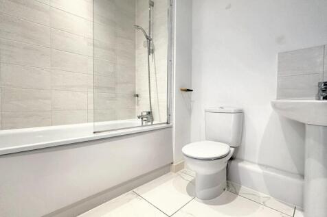 Bright and modern bathroom suite featuring a cl...