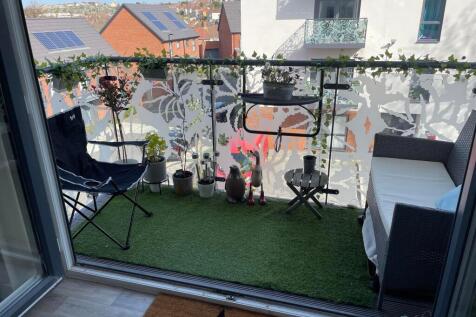 A cozy balcony space featuring artificial turf ...