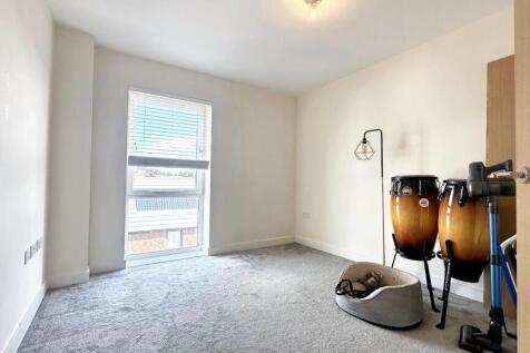 A bright and clean single bedroom featuring a l...