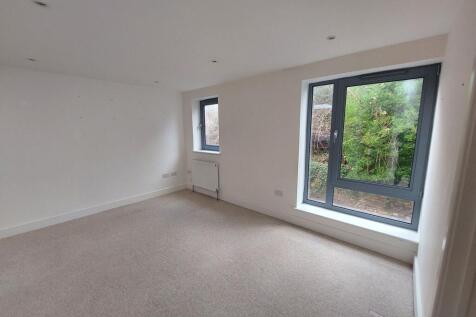 A spacious master bedroom featuring large windo...