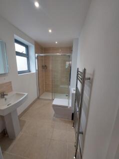 Bright and modern bathroom featuring a walk-in ...