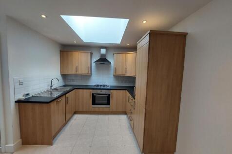 Bright and modern kitchen featuring ample woode...