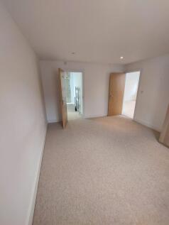 A clean and spacious double bedroom featuring n...