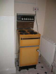 Compact kitchen area featuring a vintage yellow...