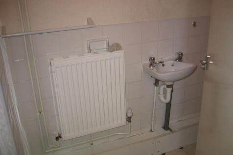 A small, functional toilet area featuring a whi...