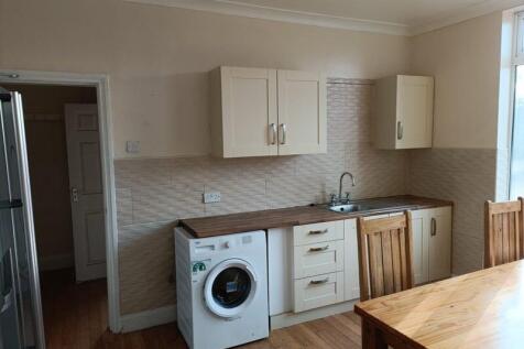 A bright and tidy kitchen featuring wooden coun...