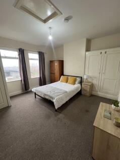 A spacious double bedroom featuring a double be...