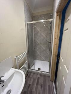 A neat and modern bathroom featuring a glass-en...