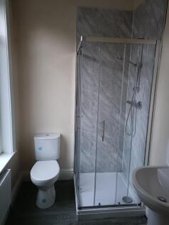A clean and modern bathroom featuring a glass-e...