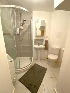 Modern bathroom featuring a curved glass shower...