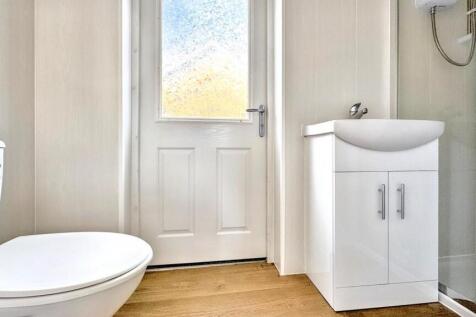 Bright and modern bathroom suite featuring a cl...