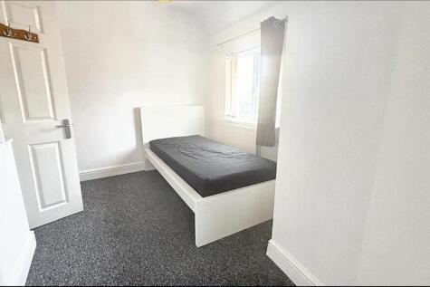 A neat and bright bedroom featuring a single be...