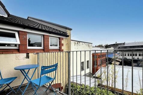Sunny outdoor balcony area featuring a small ta...