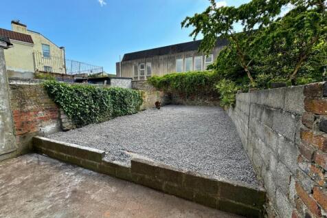 A tidy, enclosed garden area with a spacious gr...