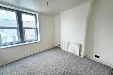 A bright and clean single bedroom featuring a l...