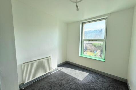 Bright single bedroom with a large window letti...