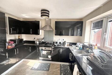 A modern kitchen with sleek black cabinetry, st...