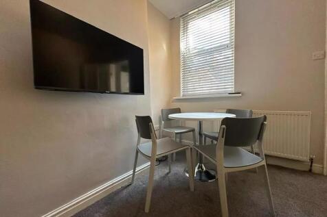 A cozy communal lounge area featuring a round t...