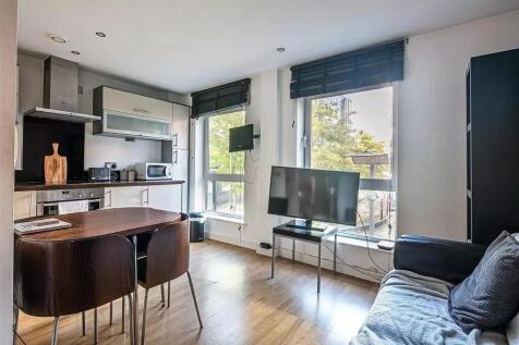 Bright and modern living room featuring large w...