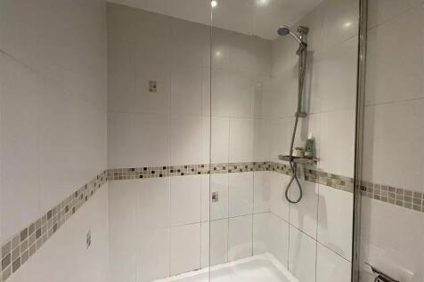 A modern bathroom featuring a walk-in shower wi...
