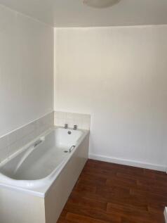 A simple bathroom featuring a clean white batht...