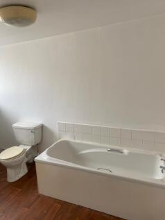 Bright bathroom suite featuring a clean white b...