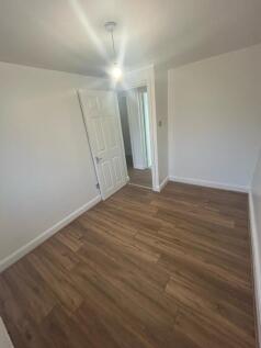 A clean and simple bedroom featuring wood-effec...