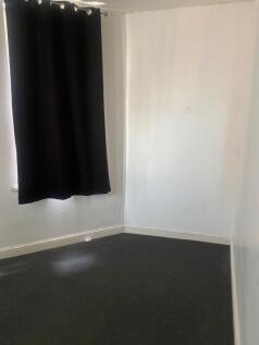 A small empty room with white walls and a black...