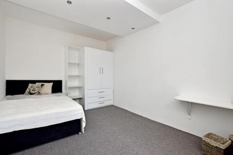 A clean and minimalist double bedroom featuring...
