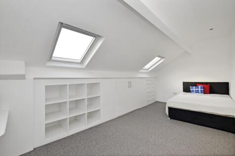 Bright and clean attic bedroom featuring two sk...