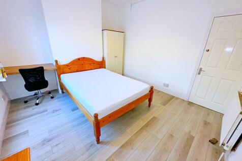 Bright and tidy double bedroom featuring a wood...