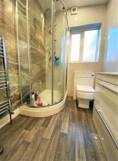 A modern bathroom featuring a curved glass show...