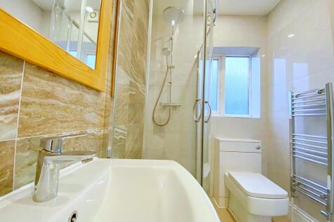 A modern bathroom featuring a sleek glass-enclo...