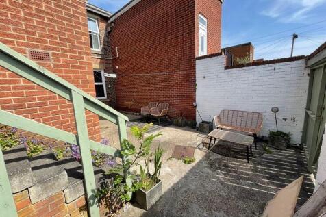 A bright, sunny private garden area featuring a...