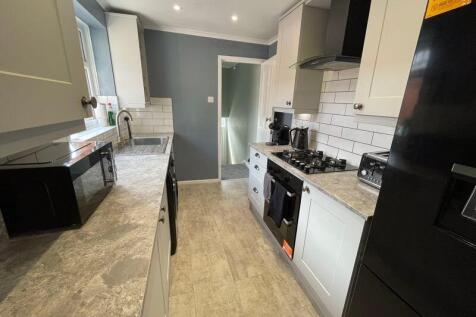 Bright and modern kitchen featuring sleek white...
